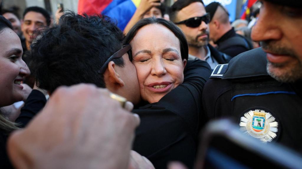 Una persona abraza a la líder de la oposición venezolana, María Corina Machado, tras la ceremonia de entrega de la Llave de Oro de Madrid.