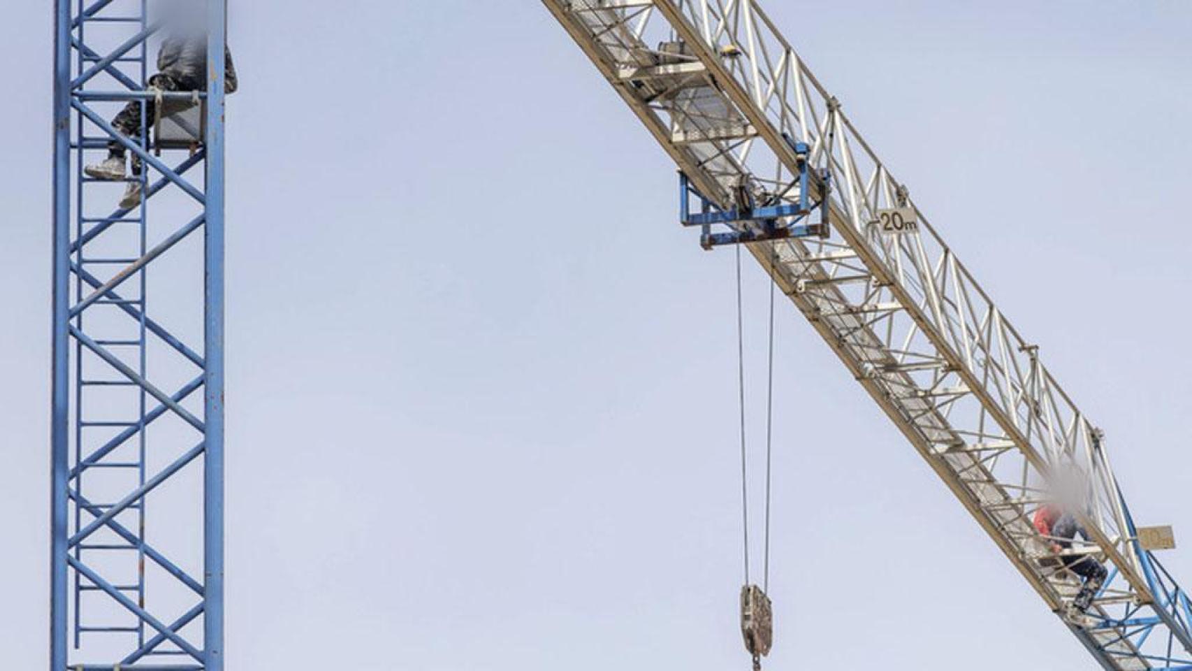 Dos trabajadores se suben a una grúa en Burgos en señal de protesta por su situación laboral.