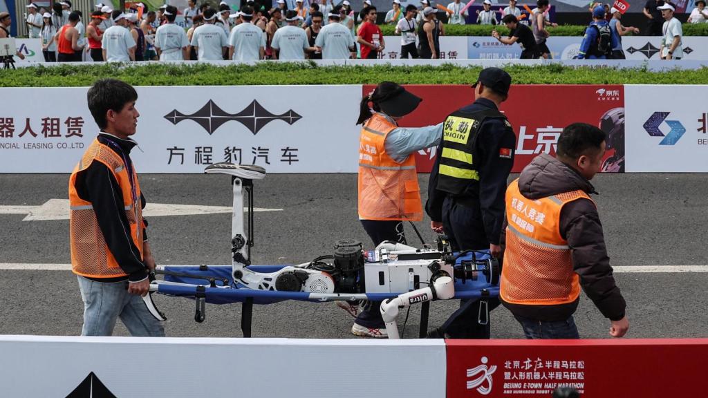Uno de los robots heridos es evacuado en camilla por los operadores.