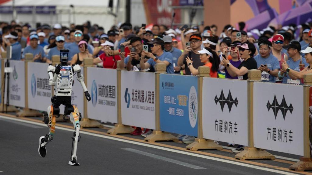 Uno de los robots participantes en la media maratón de Pekín, ante la expectación de decenas de curiosos.