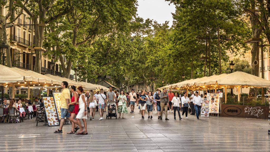 Gente paseando entre las terrazas de La Rambla.