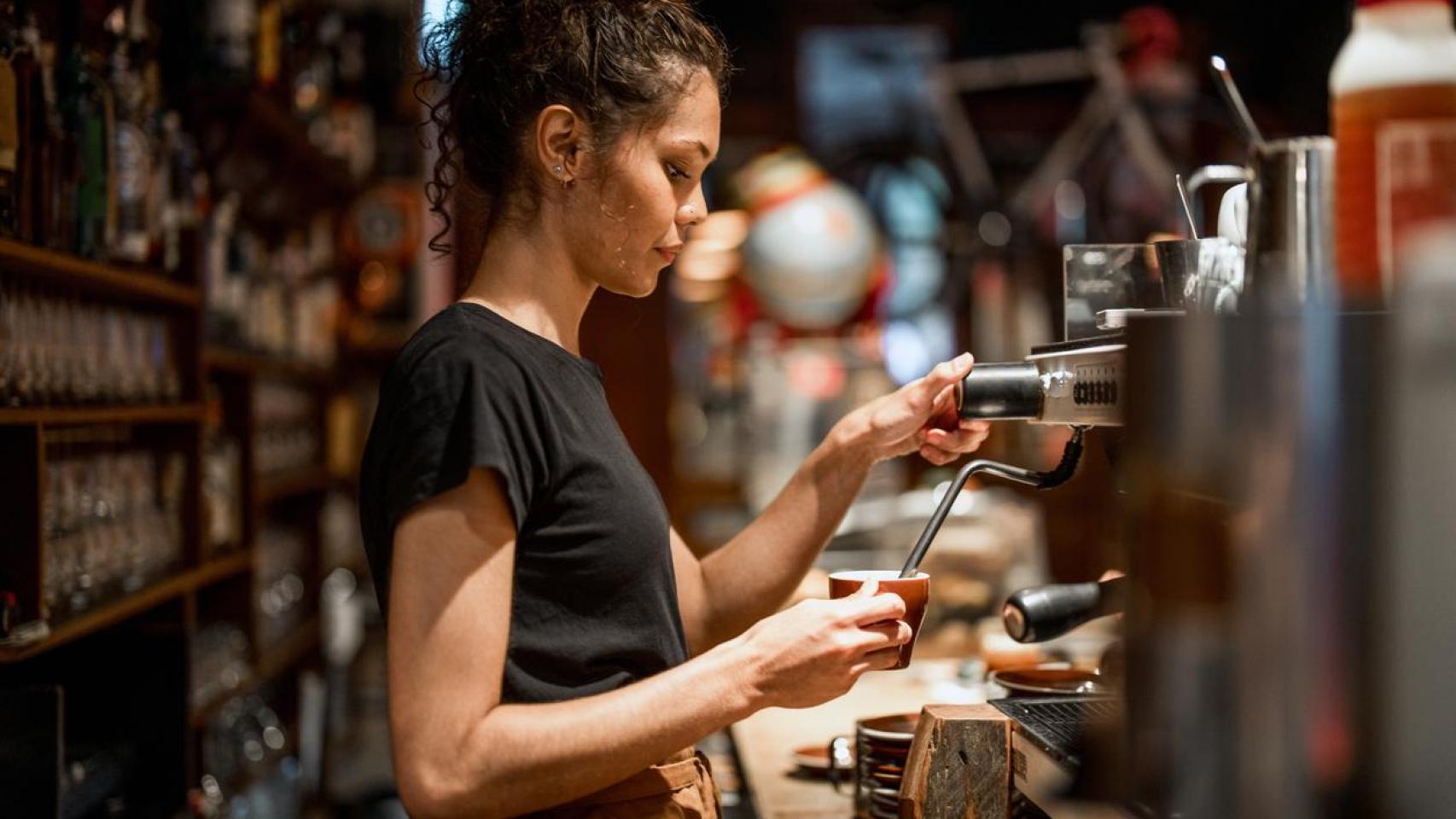 Una joven barista preparando un café.
