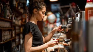 Una joven barista preparando un café.