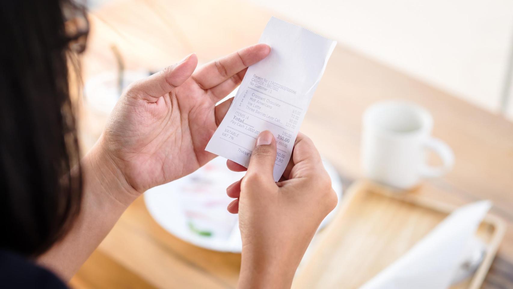 Una mujer consulta la cuenta de un restaurante.