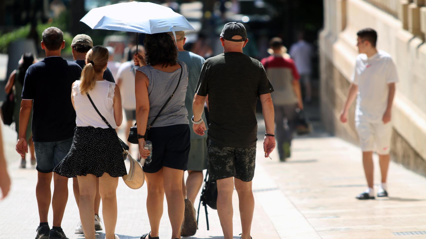 Imagen de archivo de unos turistas protegiéndose del sol en Málaga.