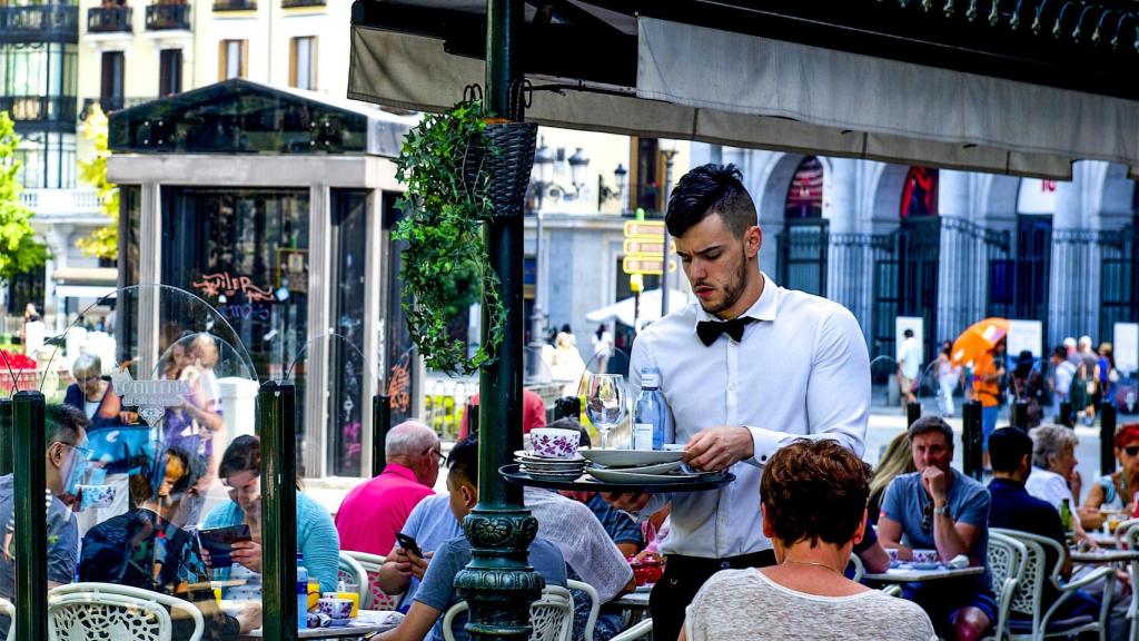 Un camarero recogiendo platos en un restaurante.