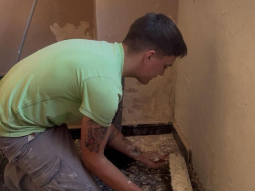 Santi colocando un rodapié en su nueva casa.