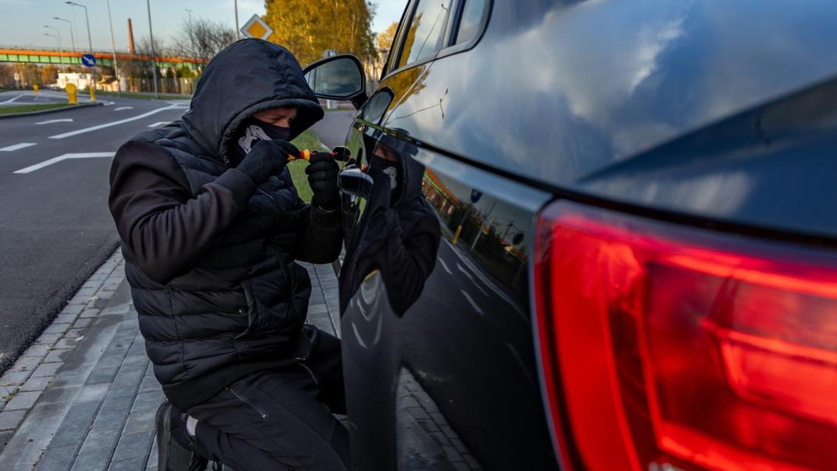 Ladrón encapuchado intenta romper los sistemas de seguridad.