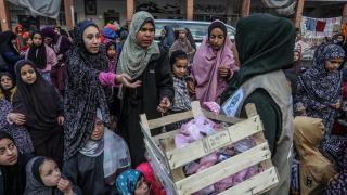 Un grupo de mujeres y niñas recibe insumos en la escuela Al-Quds, en Rafah.