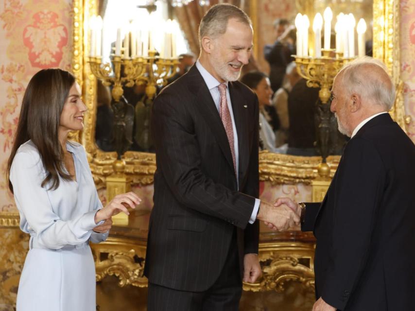La Reina trata de abrocharse el puño de la camisa durante el besamanos.
