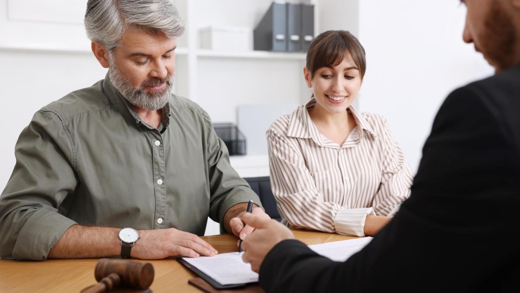 Dos personas realizando un trámite en una notaría, en una imagen de Shutterstock.