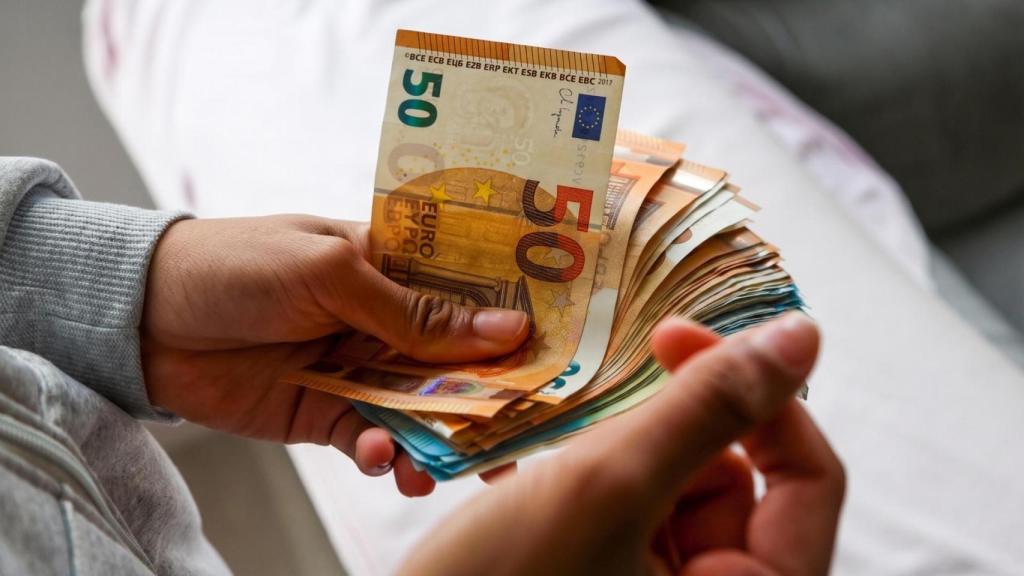 Una persona sujeta un fajo de billetes