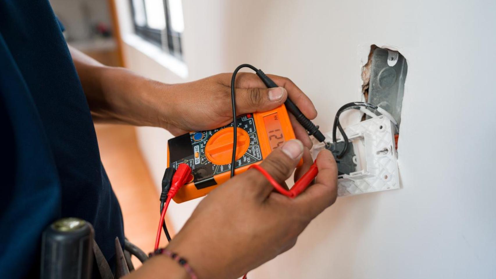 Electricista arreglando una toma de corriente.