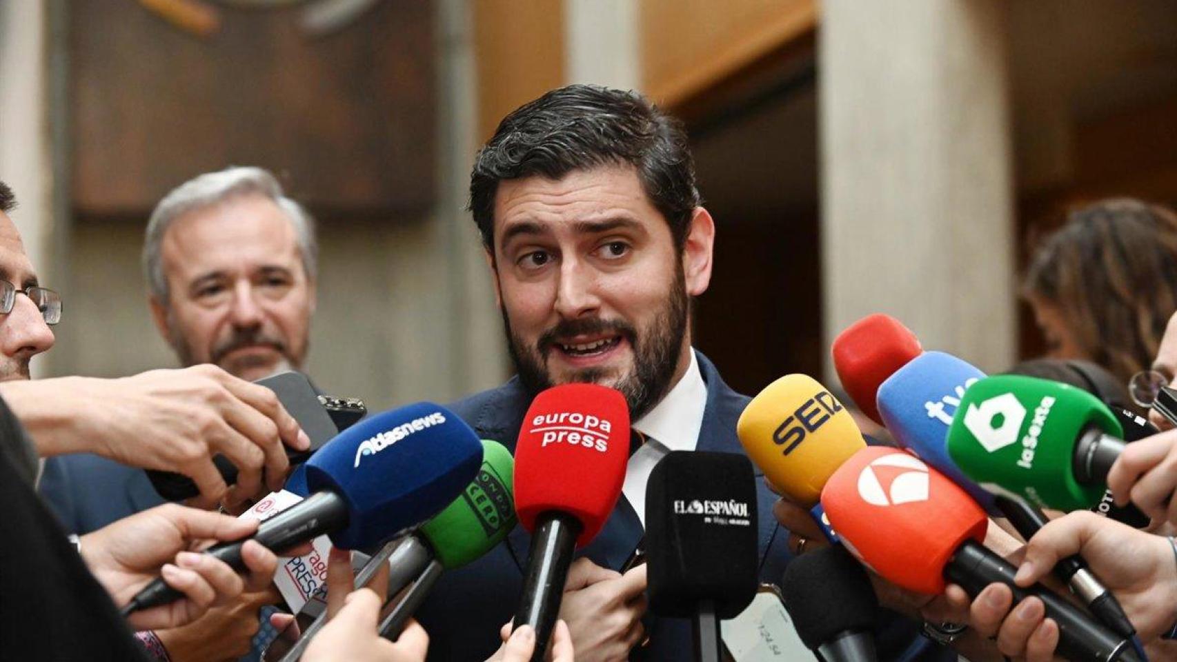 Alejandro Nolasco (Vox) atiende a los medios de comunicación mientras Jorge Azcón (PP) escucha a su espalda