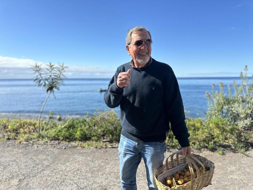 El señor Bordes, actual propietario de Fajã dos Padres, con una cesta de albaricoques recogidos de la finca.