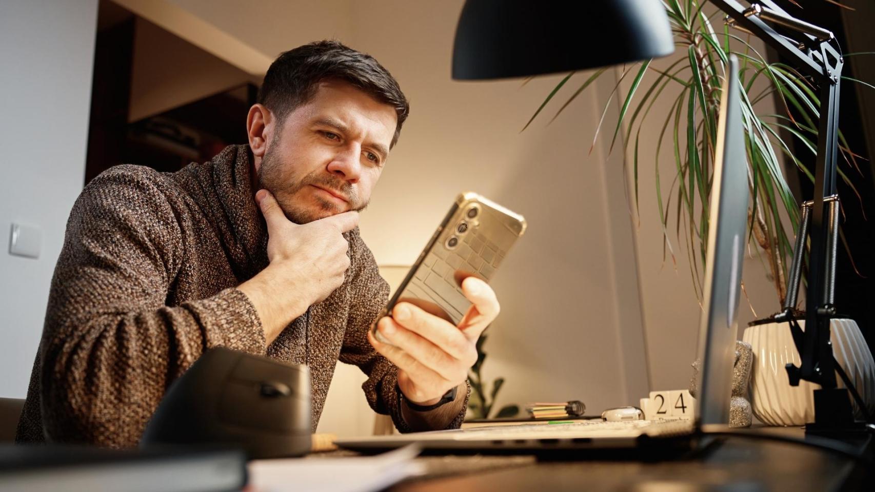 Una persona observando su teléfono.
