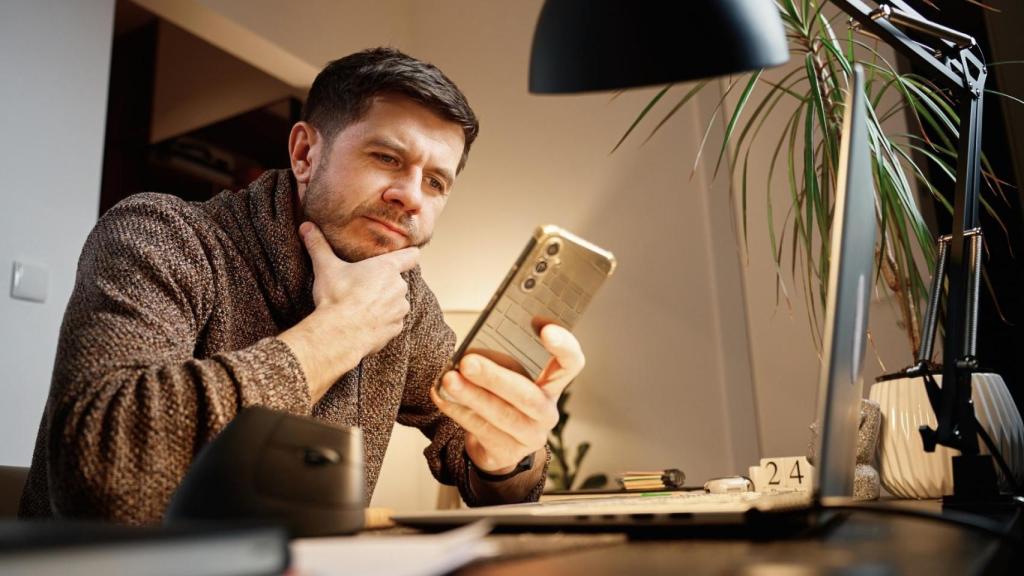 Una persona observando su teléfono.