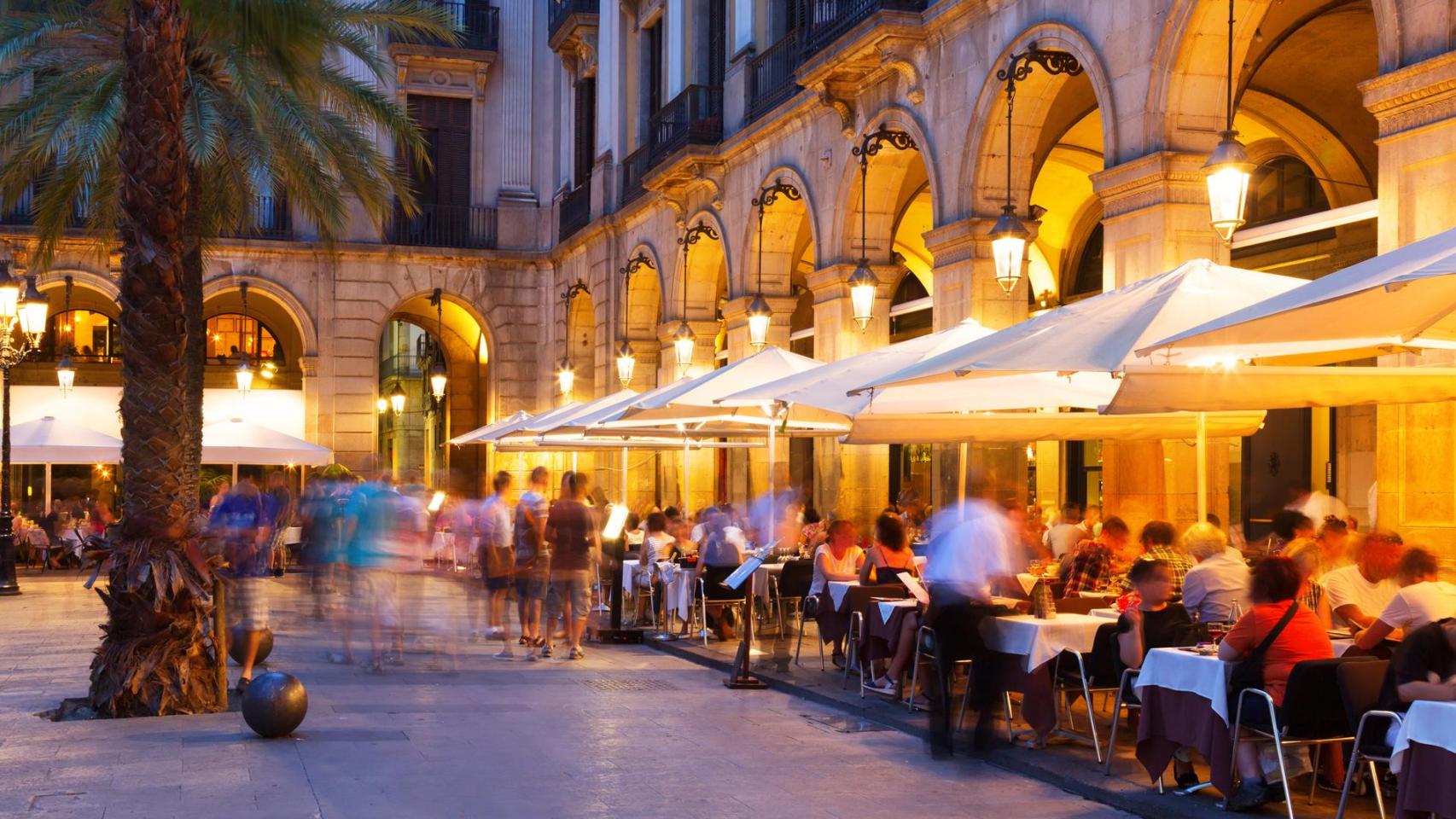 Unas terrazas de unos bares en Barcelona al anochecer. 