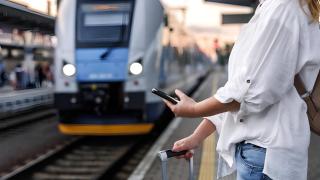 Mujer esperando en andén de estación de tren.