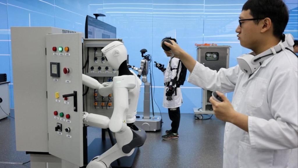 Un empleado de la empresa estatal de China demuestra el control de un robot humanoide