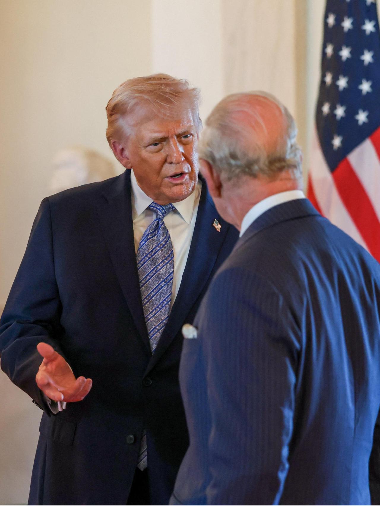 Donald Trump charlando con Carlos III.