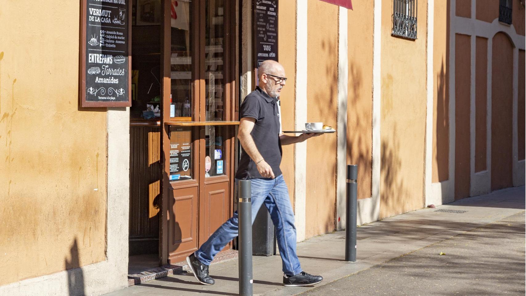 Un camarero saliendo de un bar. 