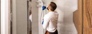 Un fontanero cambiando una bañera por una ducha.