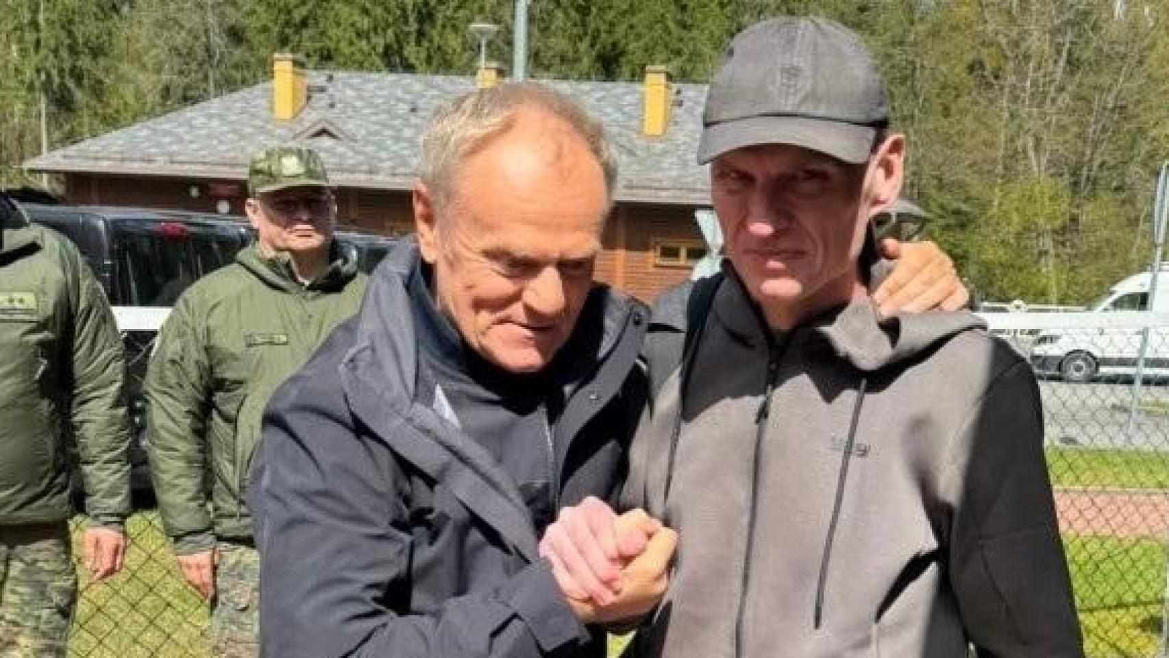 El primer ministro de Polonia, Donald Tusk (izquierda), abraza al periodista polaco, Andrzej Poczobut (derecha) tras su liberación.