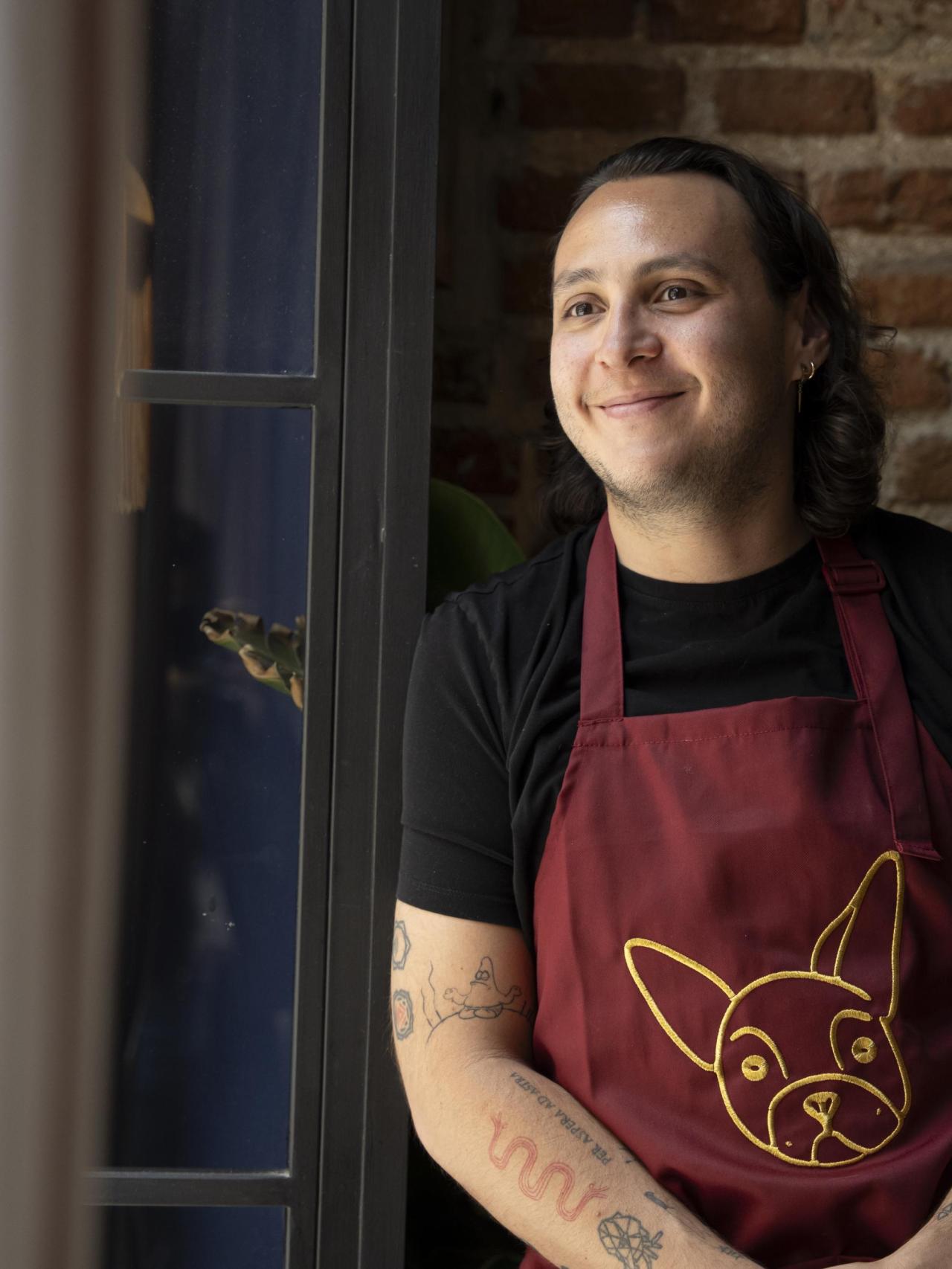 Rogelio Castro en el restaurante con su nombre, Roge, ya a su perra Croqueta en el delantal.