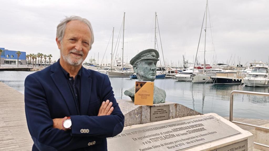 Juan Luis Mira con su nuevo libro junto al busto que recuerda la tragedia del 'Stanbrook' en Alicante. 
