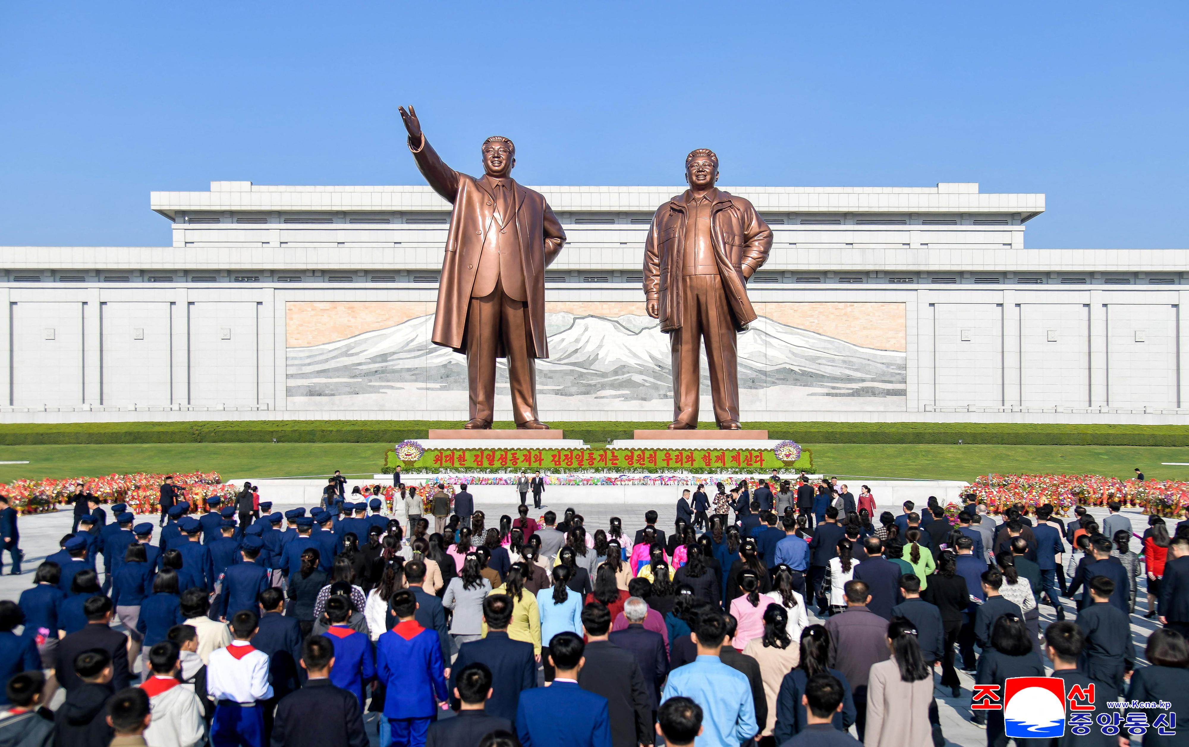 Celebración ante las estatuas del abuelo y el padre del líder supremo de Corea del Norte, Kim Il Sung y Kim Jong Il.