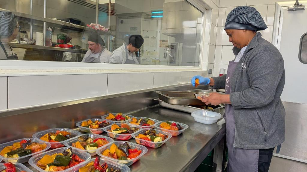 Una cocinera prepara raciones individuales para repartir en uno de los servicios de FITEI.