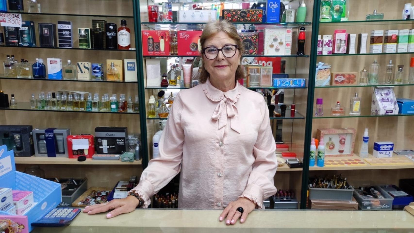 María Elena Piñeiro delante de frascos de perfume en su negocio.