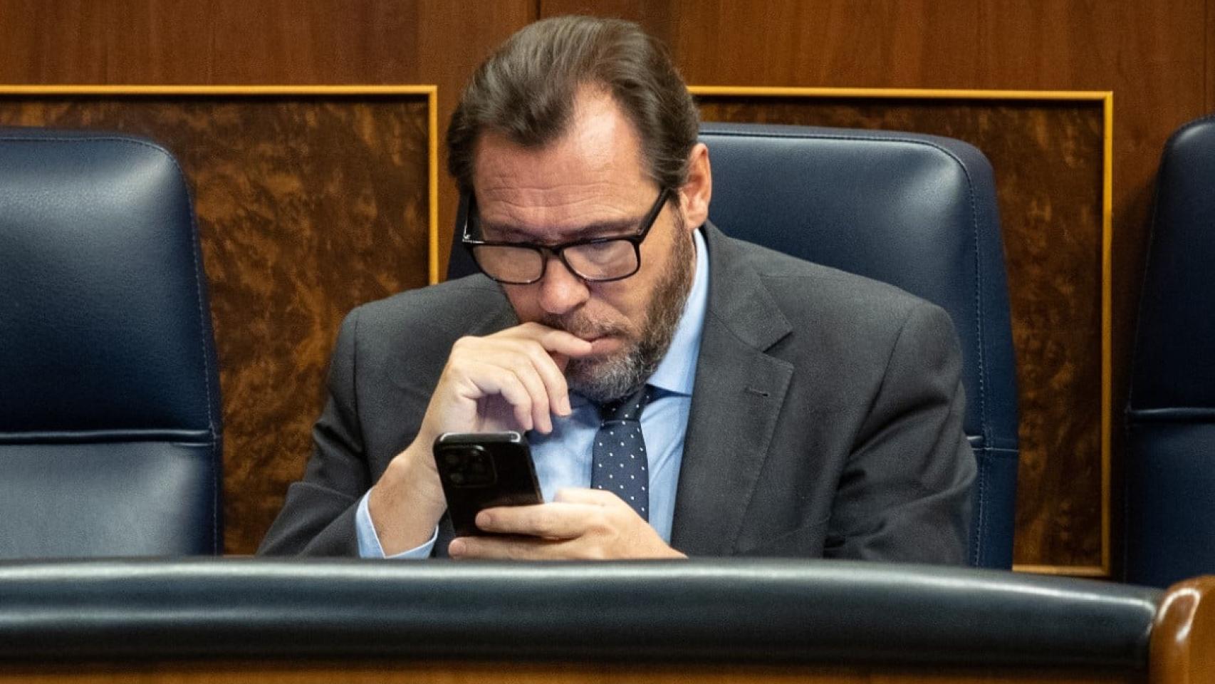 El ministro Óscar Puente consulta su móvil desde su escaño en el Congreso.