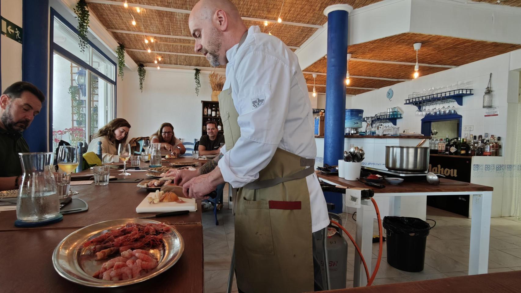 Fede Piani picando la cebolla para preparar el sofrito de uno de los arroces durante el taller que ofrece en El Gato Blanco.