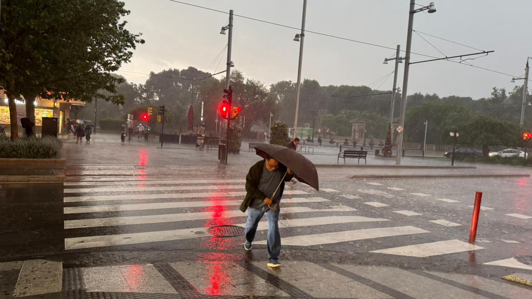 Un hombre con paraguas bajo la lluvia en Zaragoza.