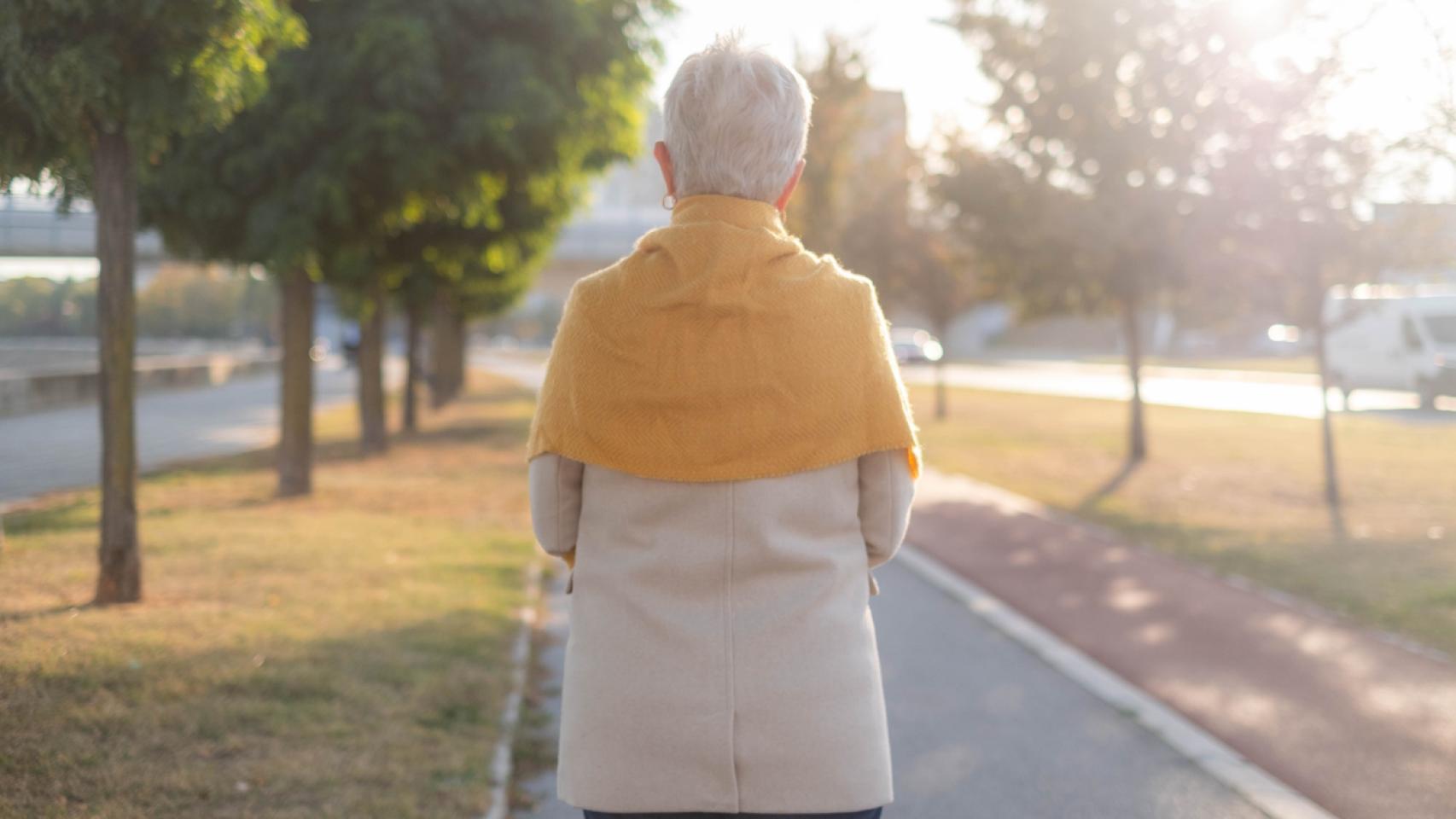 Mujer mayor caminando sola.