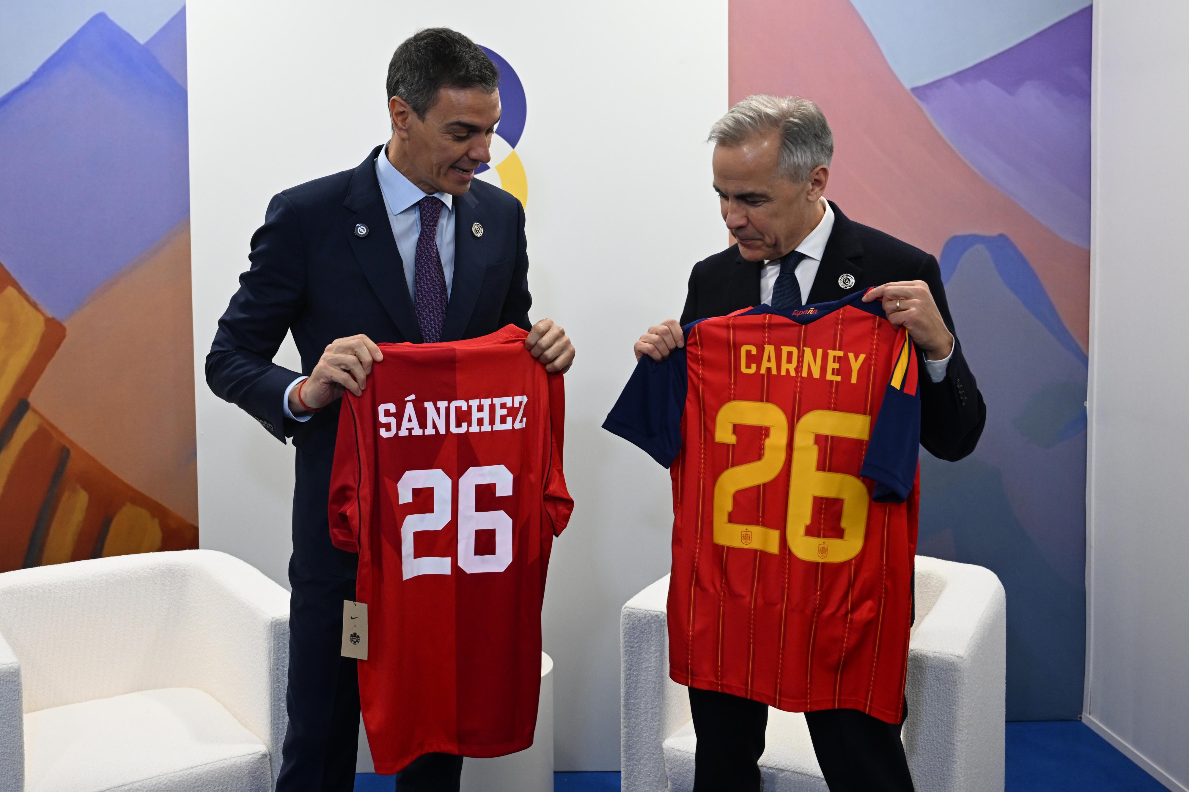 Pedro Sánchez intercambia camisetas con el primer ministro de Canadá, Mark Carney, durante la Reunión de la Comunidad Política Europea, este lunes en Ereván (Armenia).