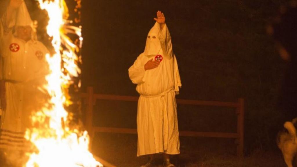 Un miembro del Ku Klux Klan saluda durante una ceremonia, en Henry County, Virginia.