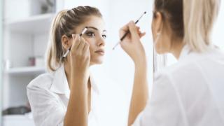 Mujer maquillándose frente al espejo