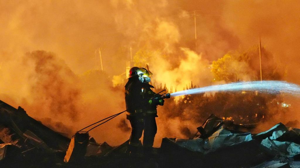 Los bomberos tratan de extinguir el fuego en la fábrica china.