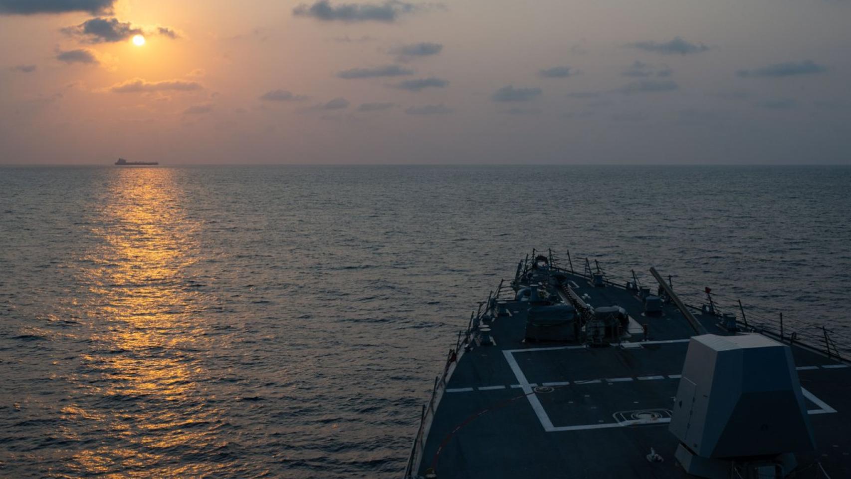 El destructor 'USS Pinckney' observa a lo lejos un buque mercante mientras realiza labores de patrulla para mantener el bloqueo marítimo a Irán.