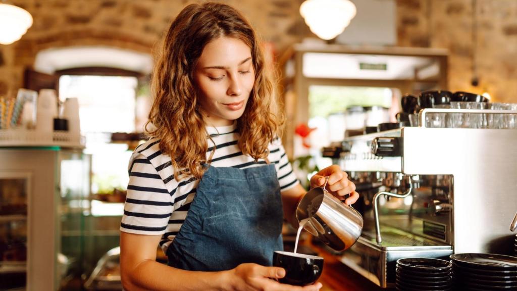 Una camarera prepara un café
