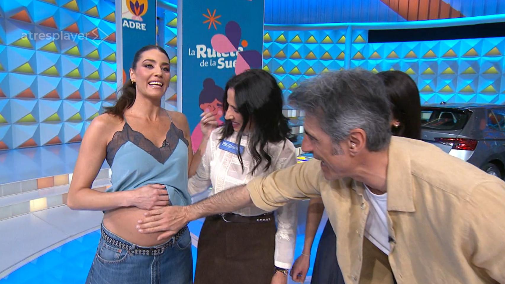 Jorge Fernández toca de forma cariñosa la barriga de su compañera, Laura Moure, en 'La ruleta de la suerte'.