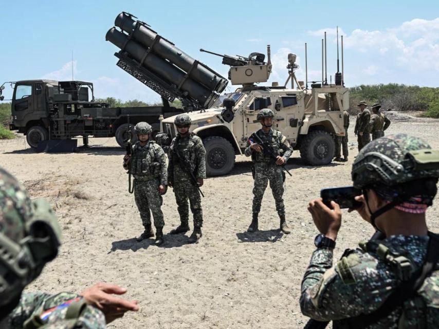 Soldados filipinos posan frente al lanzador de misiles antibuque Type 88 japonés y al sistema antiaéreo integrado MADIS de la Infantería de Marina estadounidense, durante el ejercicio Balikatan.