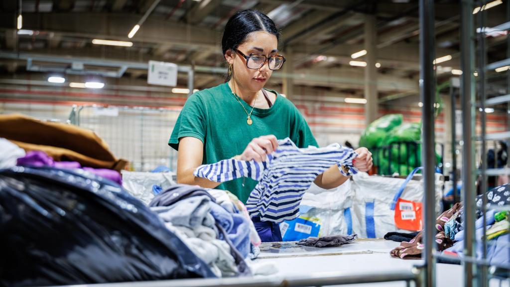 Una empleada de Humana clasifica ropa que ha llegado a la planta.