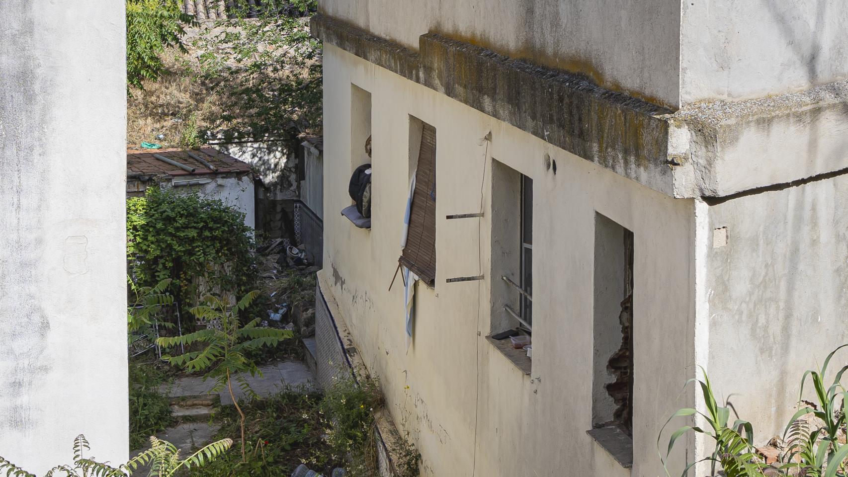 El edificio presenta signos evidentes de okupación, sin ventanas y con un aspecto de total abandono. 