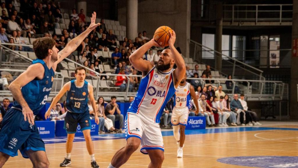 Larsen  lanza a canasta durante un partido.