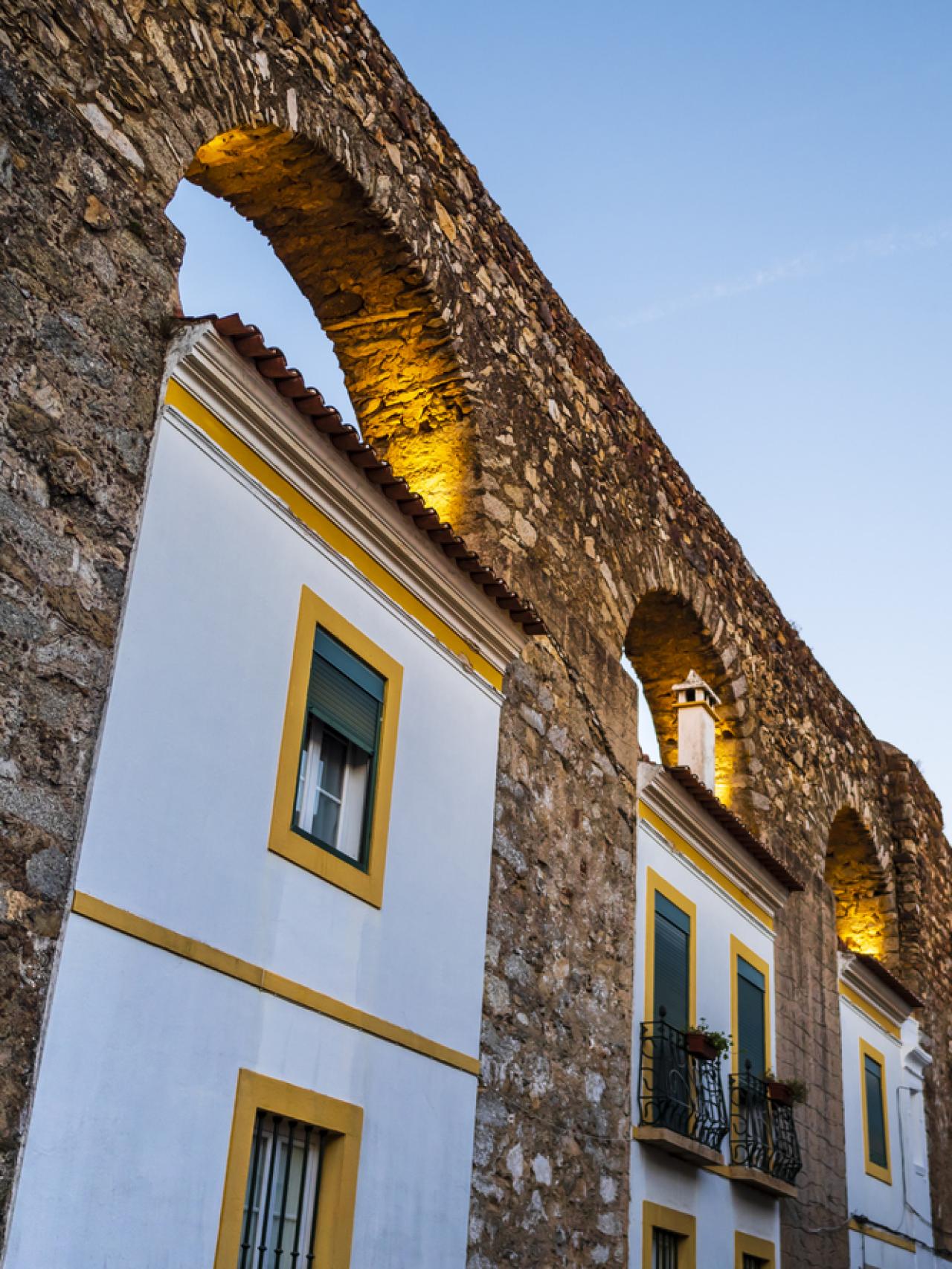 Vista pintoresca de Évora y sus tradicionales casas blancas incorporadas a los arcos del acueducto de Prata, región de Alentejo, Portugal