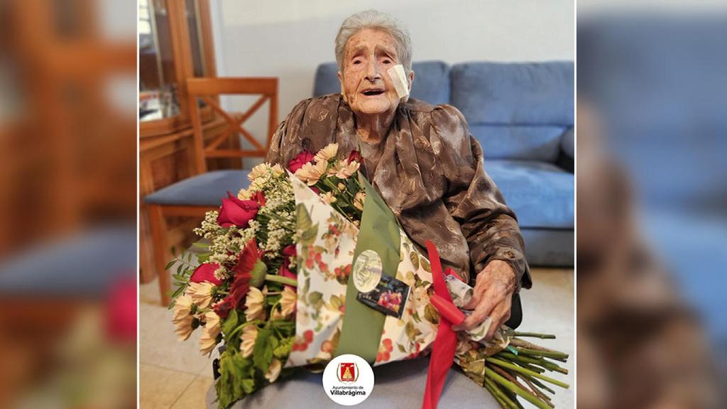 Imagen de Natividad con su ramo de flores.